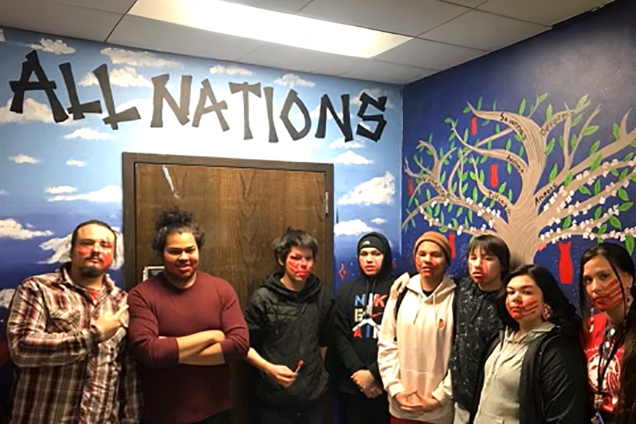 All Nations students standing in front of murals, which are now erased. The removal of the murals erased the symbolism and sense of community that All Nations students look toward in the future. 