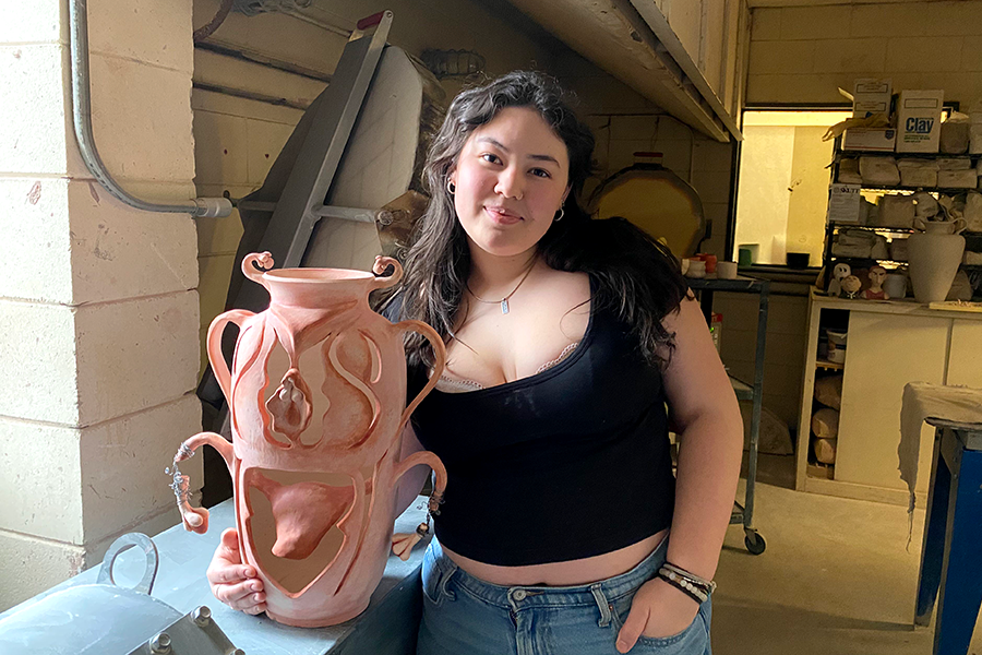 Macy Gearhart, a South Senior and Ceramicist pictured with her newest work: a vase inspired by the female reproductive system.